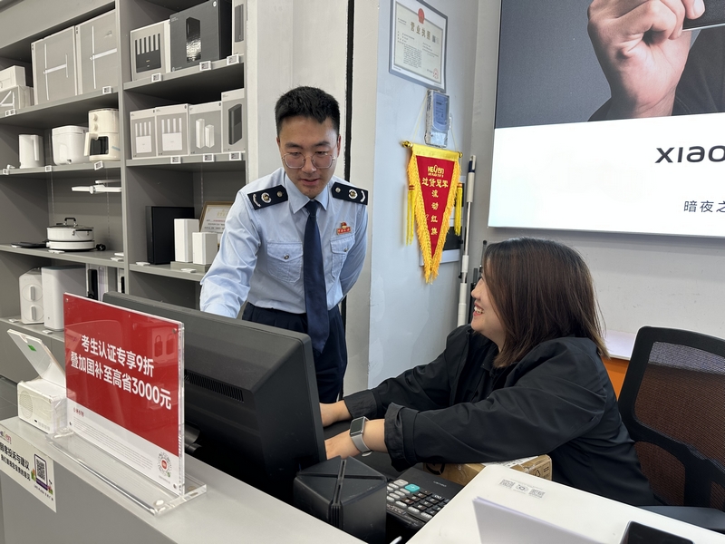 稅務干部輔導商鋪人員登錄電子稅務局系統操作。