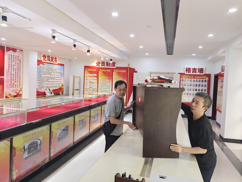 退休干部石碧玉同志（左一）與干部職工共同轉(zhuǎn)移單位底樓物資。