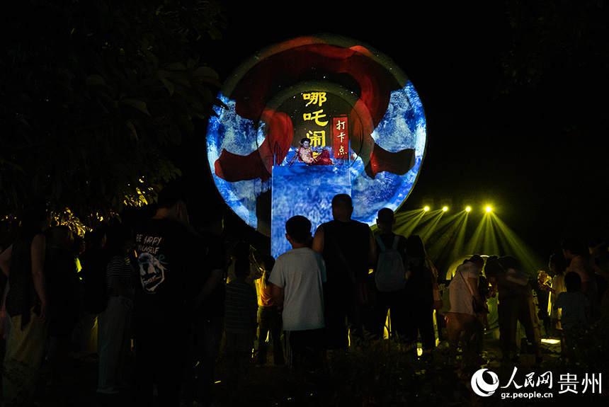 游客在景區(qū)內(nèi)的《哪吒鬧海》打卡點(diǎn)打卡。人民網(wǎng)記者 涂敏攝