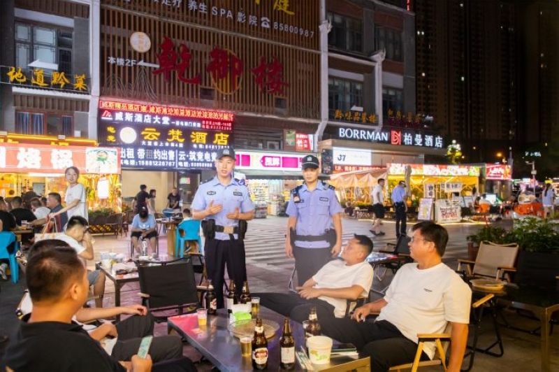世紀城派出所民警在轄區(qū)夜市巡邏，提醒群眾注意安全。觀山湖區(qū)融媒體中心供圖