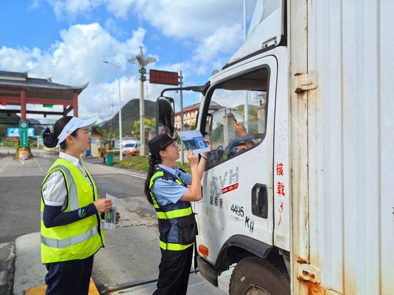 執法人員讓貨車司機掃碼提建議和意見。