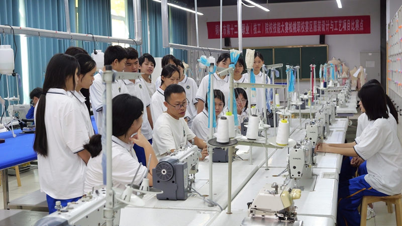 服裝設計與工藝專業學生在觀摩教師縫紉機的基礎操作。.jpg
