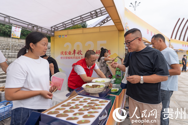 參會嘉賓品嘗修文獼猴桃。人民網記者 涂敏攝