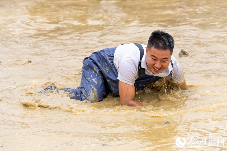 摸魚比賽現場，參賽選手在水中摸魚。人民網記者 涂敏攝