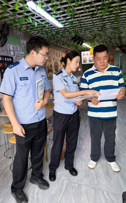 輔警向轄區群眾發放文明養犬宣傳資料。