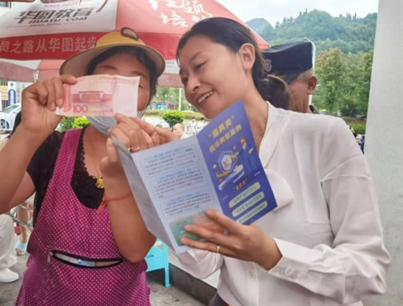 宣傳員手把手教商戶掌握人民幣防偽特征和假幣識(shí)別技巧。