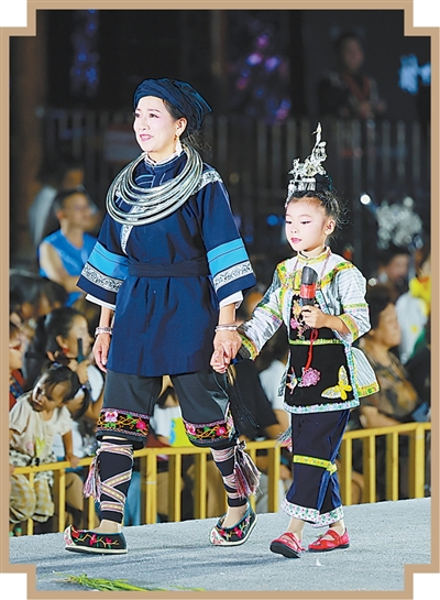 貴州凱里苗侗風情園內(nèi),村民身著民族服飾走秀。