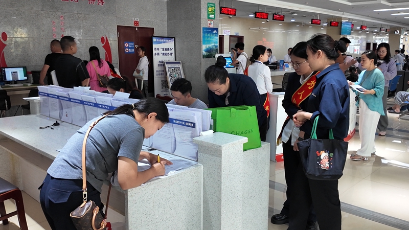 協助辦事群眾填寫資料。王璽 攝.jpg