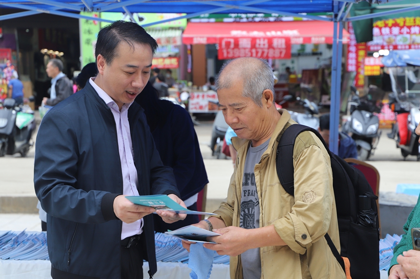貴州省文化和旅游廳工作人員正向游客詳細講解《旅游安全實務手冊》中的應急避險知識。
