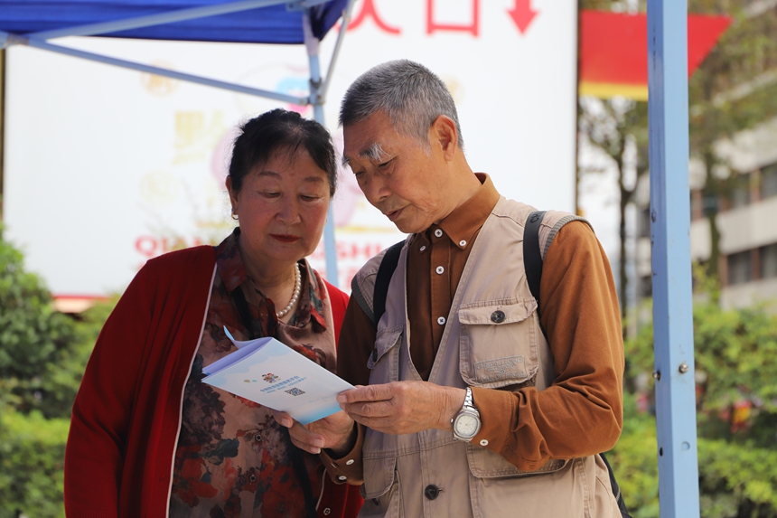 兩名游客正在認真閱讀《旅游安全實務手冊》。