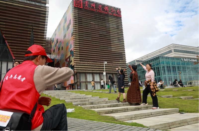 9、在貴州省博物館，觀山湖區青年志愿者為游客們拍照。張婷 攝.jpg