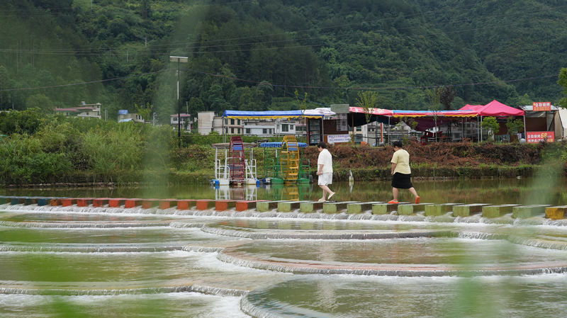 游客行走在龍里縣龍山鎮余下村魚麟壩。