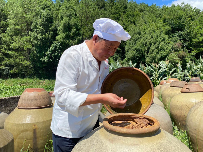 溫邦賢正在仔細查看醋醅成色。金莎攝