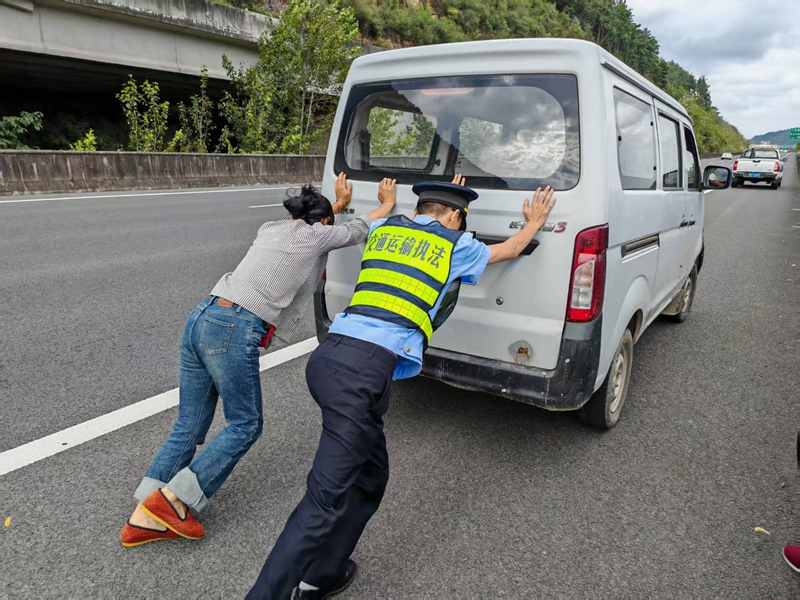 10月4日在G7521渝筑高速K308+600下行,一支隊七大隊四中隊執法人員遇故障車,幫助把車移到右側應急車道。班霞攝