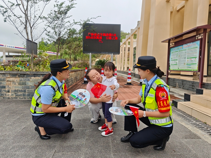 國慶期間,十大隊女子中隊隊員在服務區為司乘人員送上國旗。李玉寧攝