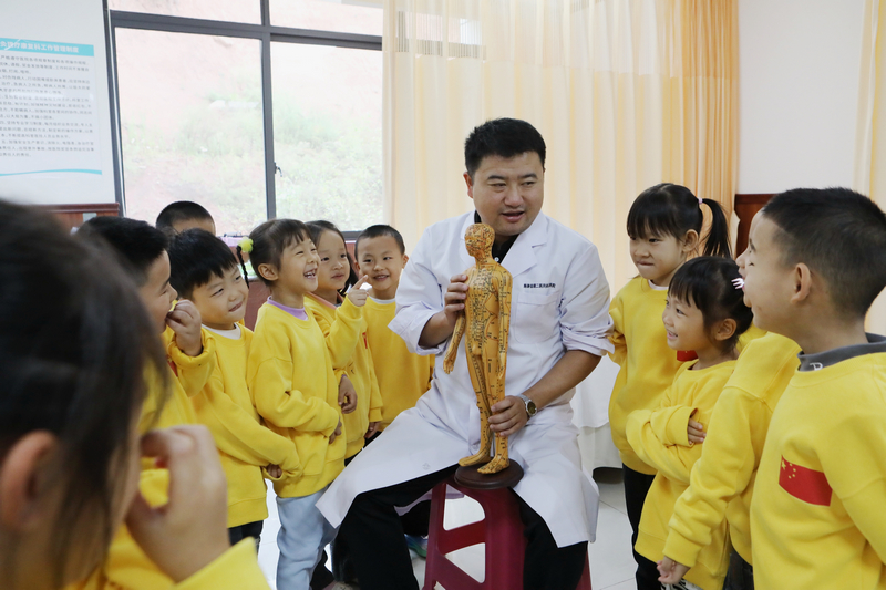 貴州省黔東南苗族侗族自治州施秉縣民族中醫院的醫生向縣第二幼兒園的小朋友們講解中醫藥知識。