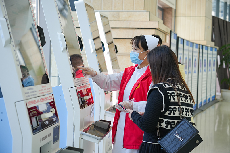 導(dǎo)診護(hù)士指導(dǎo)患者掛號(hào)就診。胡璐攝