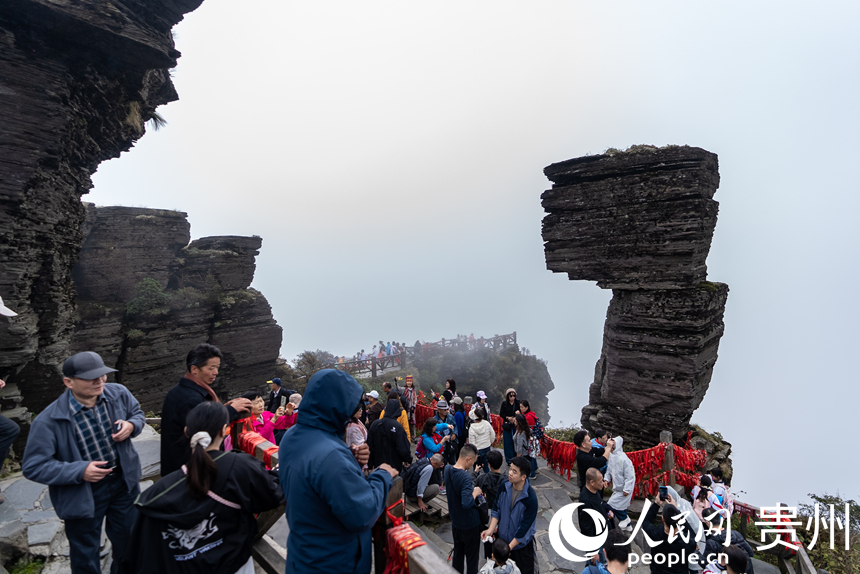 游客在梵凈山景區標志性景點“蘑菇石”處打卡拍照。人民網記者 涂敏攝