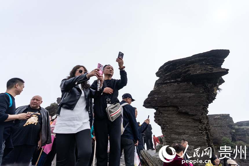 游客在梵凈山景區(qū)標(biāo)志性景點(diǎn)“蘑菇石”處打卡拍照。人民網(wǎng)記者 涂敏攝