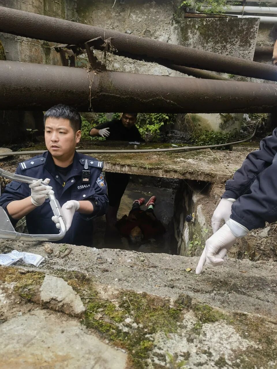 圖為民警在下水溝發現老人。
