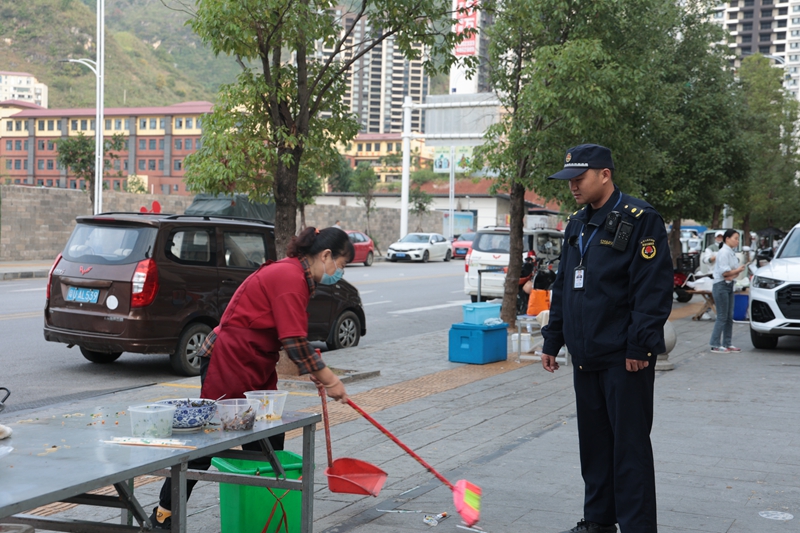 執(zhí)法人員引導(dǎo)攤販打掃衛(wèi)生.jpg