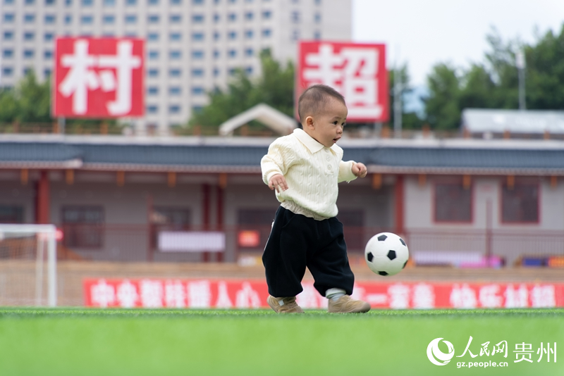 “村超”球場上,11個月大的孩子跟著足球撲騰。人民網記者 涂敏攝