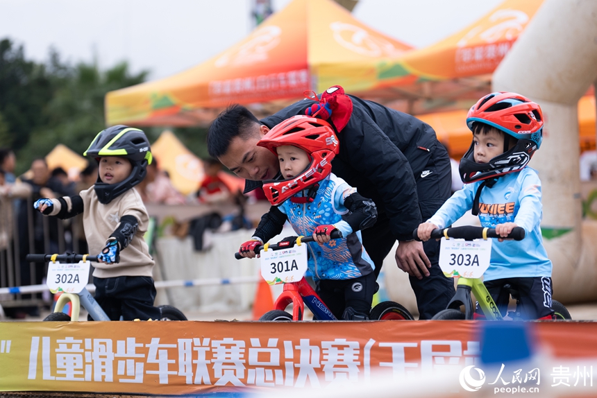 兒童滑步車(chē)項(xiàng)目比賽現(xiàn)場(chǎng),教練在賽前與參賽小朋友溝通比賽注意事項(xiàng)。人民網(wǎng)記者 涂敏攝