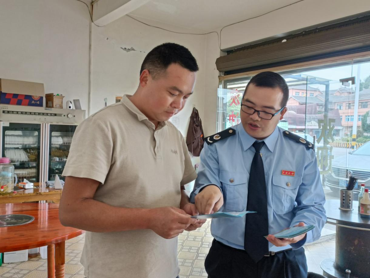 稅務(wù)人員向個(gè)體戶經(jīng)營者講解政策。高敏攝