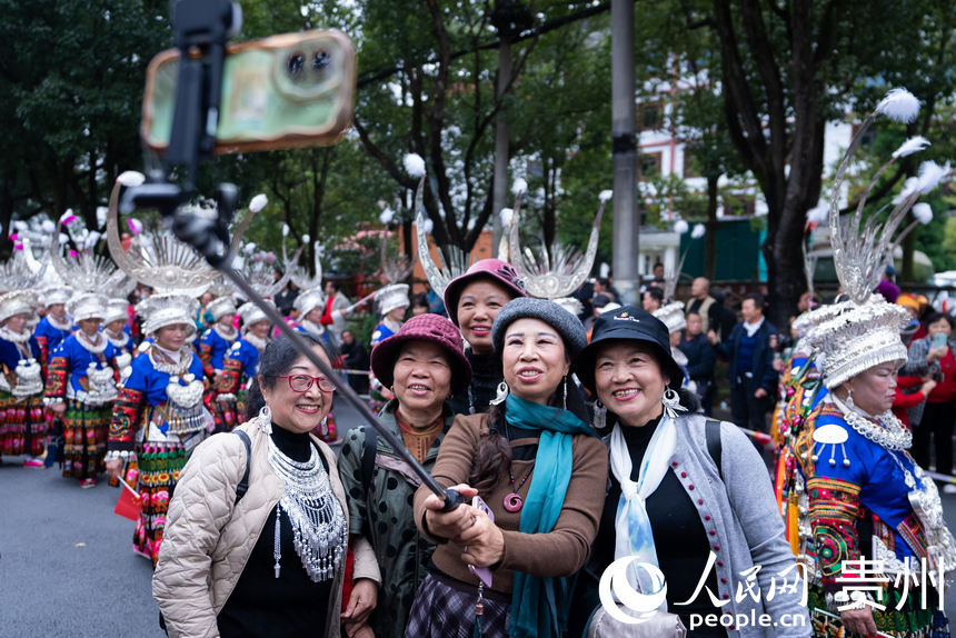 游客與非遺巡游隊伍合影。人民網記者 涂敏攝