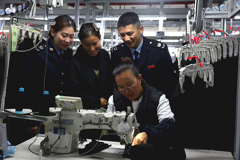 國家稅務總局黔西市稅務局關注當地出口退稅企業發展，為相關企業提供“一企一策”個性化稅費服務，輔導企業依法依規適用稅費政策，更好地防范跨境經營稅收風險。圖為稅務人員在貴州質品服飾有限公司了解生產工藝。劉一帆