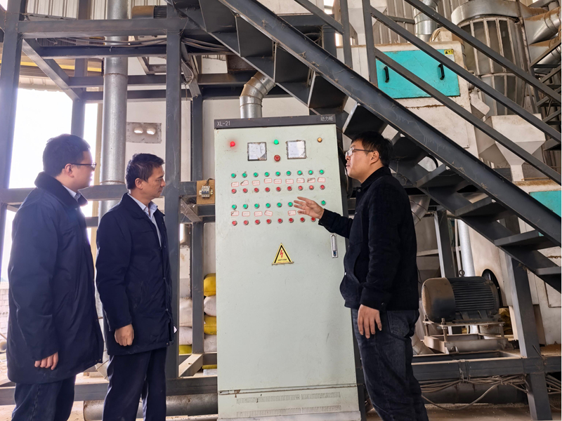 企業負責人為郵儲工作人員介紹薏仁米加工廠設備和工藝。