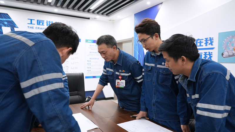 貴州黔西中水發電有限公司首席專家鄒顯未和工友們在“工匠工作室”探討專業技術問題。