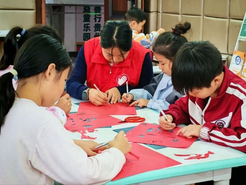 丹都街道旺家社區(qū)的志愿者和社區(qū)孩子們一起進(jìn)行剪紙創(chuàng)作。