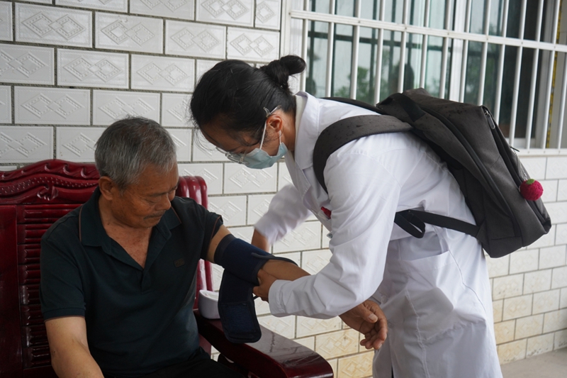 村醫正在給老人量血壓。