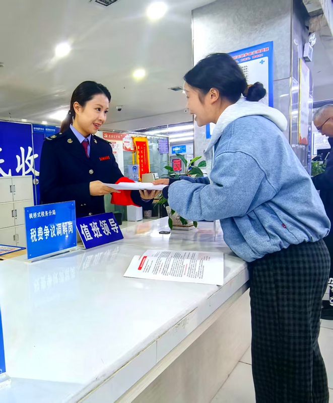 稅務干部為納稅人辦結稅務事項并講解相關稅費優(yōu)惠政策。童霖攝