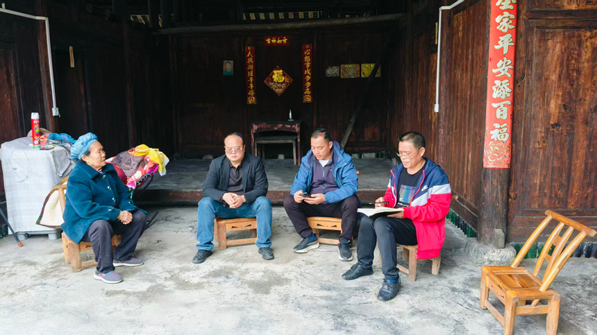 松桃雞爪社區駐村干部、村干部上門送醫保政策。