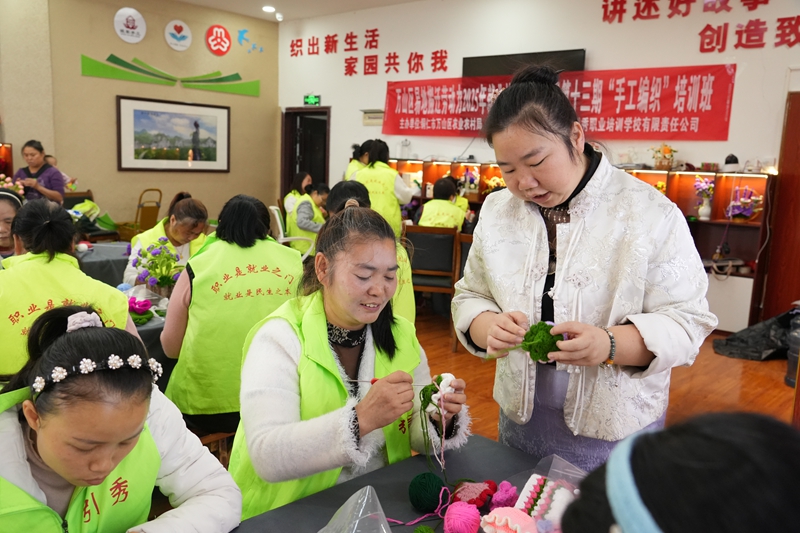 在丹都街道旺家社區(qū)微工廠手工傳習(xí)基地，負(fù)責(zé)人許平正手把手地向?qū)W員傳授毛線鉤織技巧.jpg