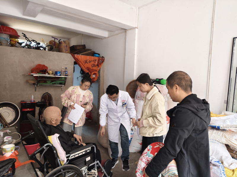 工作人員正在為梁承松老人做“上門評殘”工作。
