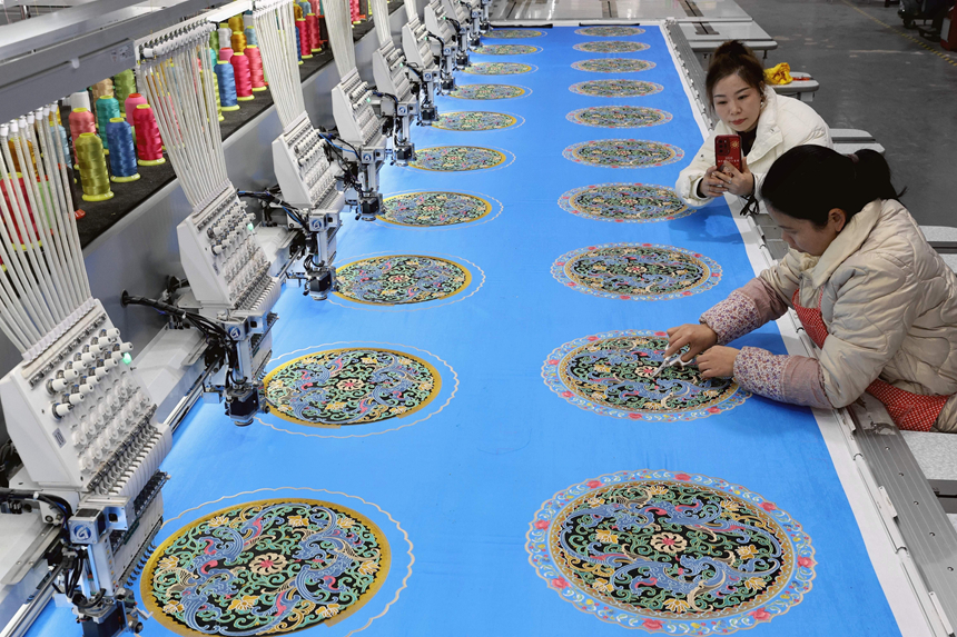 在貴州省黔東南苗族侗族自治州施秉縣一家非遺機(jī)繡生產(chǎn)車間，主播在直播推銷苗繡產(chǎn)品。