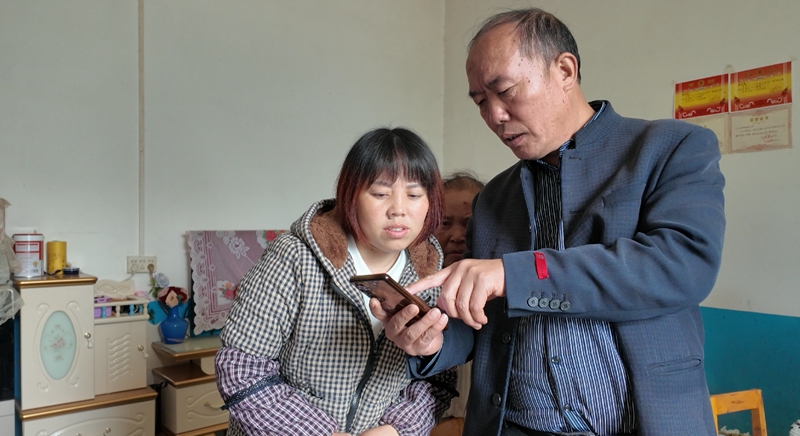 村干部正在教群眾繳納醫(yī)保。 彭垚 攝.jpg