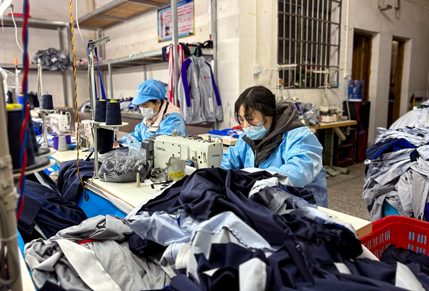 姚合云（右）在制作衣服。