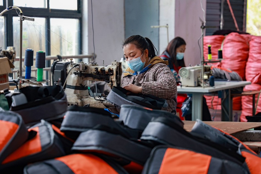 劉連清在制作背包。