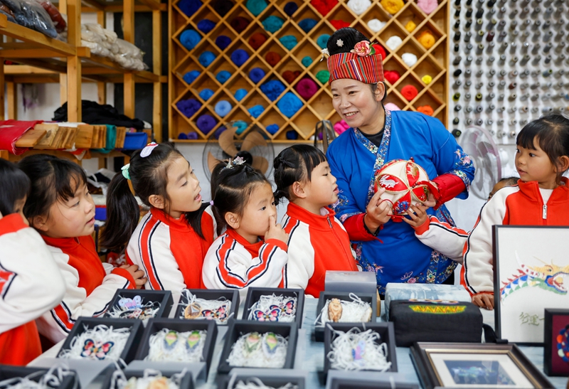 2025年12月10日非遺代表性傳承人在給貴州省黔東南苗族侗族自治州施秉縣第四幼兒園的孩子們傳授苗繡知識。