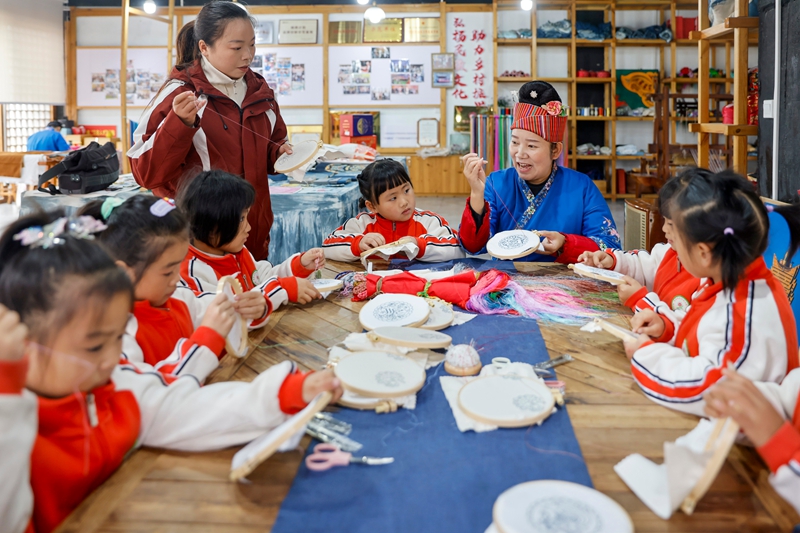 2025年12月10日，貴州省黔東南苗族侗族自治州施秉縣第四幼兒園的孩子們在非遺代表性傳承人的指導下體驗苗繡技藝。