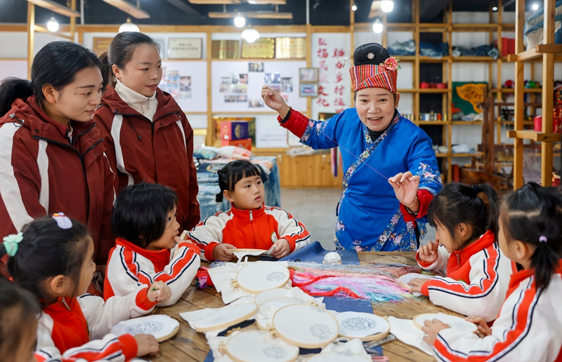 2025年12月10日，貴州省黔東南苗族侗族自治州施秉縣第四幼兒園的孩子們在非遺代表性傳承人的指導下體驗苗繡技藝。