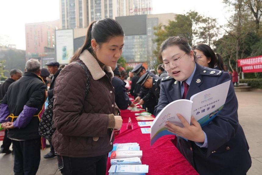 稅務(wù)干部在服務(wù)臺前為群眾面對面解答疑問。李琪攝