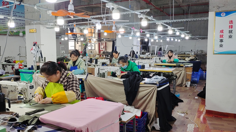 工人們正緊張有序地加工各式各樣的服飾。