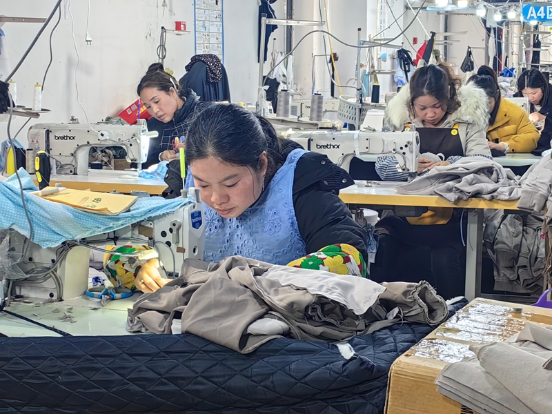 工人們正緊張有序地加工各式各樣的服飾。