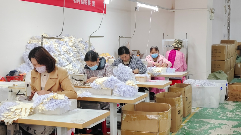 工人們正緊張有序地加工各式各樣的服飾。