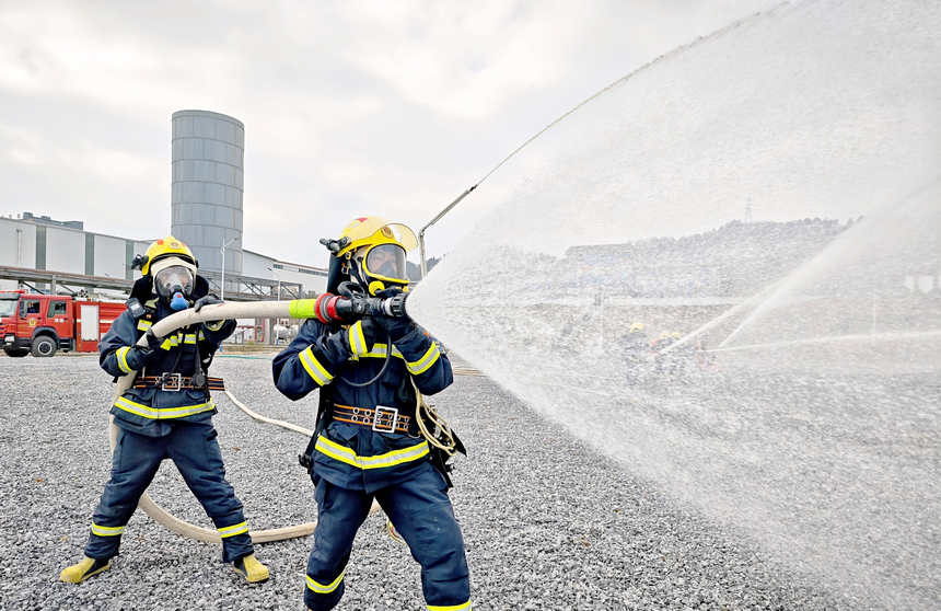 消防員全副武裝進(jìn)行演練。